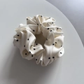 Detalle de coletero de satén crema con elegantes lunares negros y pliegues de alta calidad - Beige con lunares