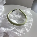 Detalle de la diadema de tela verde claro que muestra la etiqueta tejida Hand Made - Verde