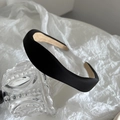 Detail view of black padded satin headband featuring smooth texture and beige non-slip lining - Black