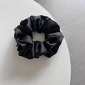 Primer plano de coletero de satén negro que muestra tela brillante y pliegues sedosos - Negro