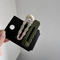 Close-up of wavy acetate hair clips in iridescent white and olive green on a black card - 2 Pcs/Set / Dark Green