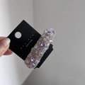 Dettaglio del fermaglio in cristallo viola con bordi in metallo su cartoncino nyunyu - Viola