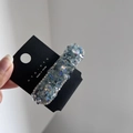 Dettaglio di fermaglio per capelli in cristallo con strass blu su carta nera - Blu