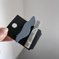 Dettaglio di due fermagli in acetato con motivo marmorizzato e ciondolo a fiocco dorato - Blu Nebbia