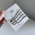 Set of four minimalist silver wavy metal hair clips on a white display card - Silver