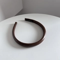 Detail eines braunen Leder-Stirnbands mit handgefertigtem schwarzem Stoffetikett innen - Braun