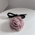 Gros plan d'un chouchou rose en forme de rose avec des bords noirs et un élastique épais - Rose