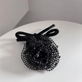 Detailopname van een handgemaakte zwarte mesh bloem haaraccessoire met elegante textuur - Zwart