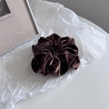 Detail of dark brown velvet scrunchie with sparkling white beads on a textured background - Khaki