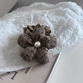 Detalle de coletero de flores en tweed con perla blanca y volante de satén marrón - Caqui