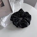 Detailopname van zwarte satijnen scrunchie met glanzende strass-steentjes op kunstachtergrond - Zwart