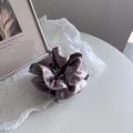 Close-up of a dusty purple satin scrunchie with elegant folds and silky luster texture - Purple Pink