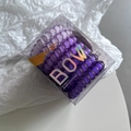 Close-up of purple spiral hair ties in a transparent square gift box with laser logo - Purple