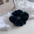 Macro shot of dark blue velvet scrunchie showing soft texture and pleated details - Teal