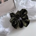 Macro shot of dark green velvet scrunchie showing soft texture and pleated craftsmanship - Green