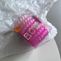 Macro detail of gradient pink spiral hair ties in transparent box with BOW branding - Rose Red