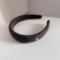Detalle de diadema de lana gris con adorno ovalado de plata y textura suave - Café Claro