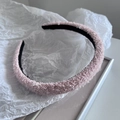 Detail eines rosa flauschigen Haarreifs mit funkelnden Pailletten und schwarzem Futter - Rosa