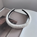 Primer plano de una diadema de felpa blanca con lentejuelas y forro interior negro antideslizante - Estilo Estrecho / Blanco Roto