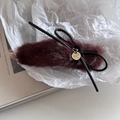 Vue détaillée d'une pince à cheveux en peluche bordeaux avec pendentif en métal doré - Bordeaux