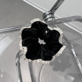 Détail du chouchou en velours noir avec bords blancs volantés et médaillon argenté - Noir