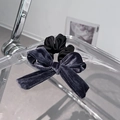 Detailed view of the dark grey velvet bow and satin scrunchie on an acrylic tray - Grey Blue