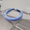Close-up of light blue padded plaid headband showing knit texture and HAND MADE label - Blue