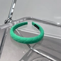 Detalle de la diadema de tela acolchada verde hecha a mano con etiqueta de fabricación - Verde