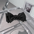 Dettaglio dell'elegante fermaglio a banana con fiocco in raso nero su base acrilica - Stile Clip a Banana con Fiocco in Raso / Nero