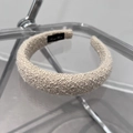 Dettaglio del cerchietto imbottito intrecciato beige con etichetta fatta a mano - Tessuto a Trama (TK60) / Beige