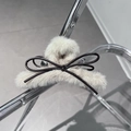 Detalle de una pinza para el pelo de peluche grande con lazo negro y pelo beige - Beige
