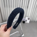 Dettaglio del cerchietto in peluche blu scuro con etichetta fatta a mano e morbida - Blu navy