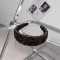 Close-up of a brown satin braided headband with cross-weave texture and elegant glossy finish - Brown