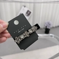 Dettaglio del fermaglio per capelli in velluto con strass brillanti sulla carta espositiva - Design a Fiore
