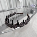 Détail d'un serre-tête en tissu écossais marron avec dents et bouton papillon élégant - Style Peigne