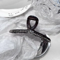Detailed close-up of dark purple bow hair claw clip with grey rhinestones and pearls - Square Diamond Cross Style