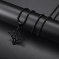 Macro detail of a black matte witch knot pendant with square chain on a dark pedestal - Black Witch Knot Necklace