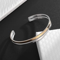 Vista detallada del brazalete bicolor de acero inoxidable con plata y oro cepillado - Dorado y Plata