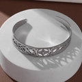 Macro detail of silver stainless steel witch knot bangle showing intricate celtic patterns - Silver