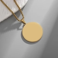 Close-up of minimalist gold-plated stainless steel round pendant on a box chain - Gold