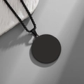 Detail view of a matte black round pendant necklace with a durable box chain - Black