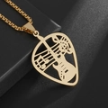 Macro shot of gold guitar pick pendant with hollowed music notes on black gift box - Gold