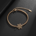Gros plan détaillé du bracelet mandala en acier inoxydable doré sur fond en cuir noir - Doré