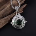 Vista macro laterale del ciondolo vintage in argento con motivi intagliati e gemma verde - Collana Medaglione Tondo Verde Scuro