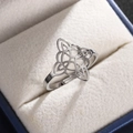 Detailed view of silver stainless steel Celtic knot ring on a white jewelry box lining - Silver