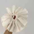 Close-up of oversized cream pleated scrunchie with delicate sheer striped fabric texture - Apricot