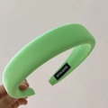 Detail of light green thick sponge headband with a hand made label and woven texture - Green