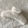 Detailed view of large cream plush hair claw clip with soft faux fur texture for women - White