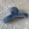 Détail de la pince à cheveux en peluche bleu-gris avec boule en fourrure et design courbé - Bleu