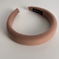 Detalle de la diadema de esponja rosa palo con etiqueta artesanal y textura de tela - Rosa Palo
